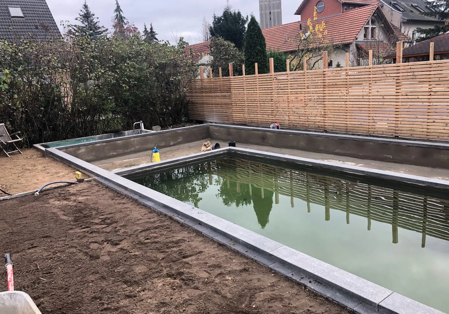 Fertiger Naturpool aus Teichkomposit mit klarem Wasser und Terrasse
